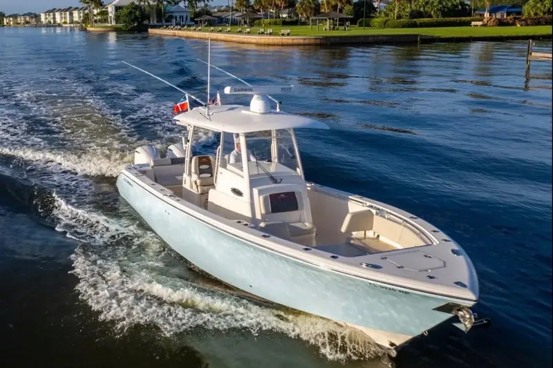 Slide: The Image of 2018 Cobia 320 Center Console boat cruising on a calm waterway. - 9
