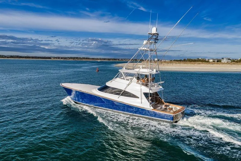The Image of 2022 Viking 72 Convertible yacht cruising on open water under a clear blue sky. - 0