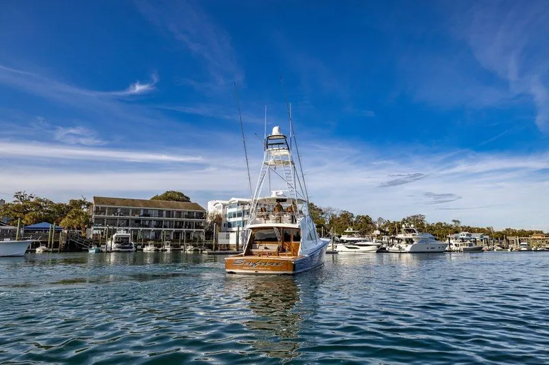 Slide: The Image of 2022 Viking 72 Convertible yacht in a scenic marina setting. - 11