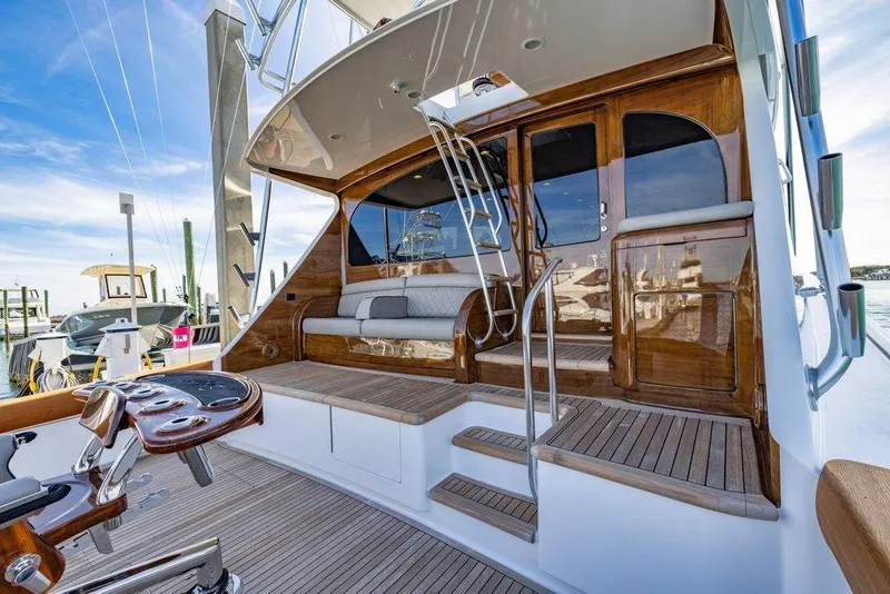 Slide: The Image of 2022 Viking 72 Convertible yacht with elegant wooden deck and seating area. - 13