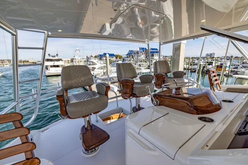 Slide: The Image of Luxurious 2022 Viking 72 Convertible yacht helm with marina view. - 19