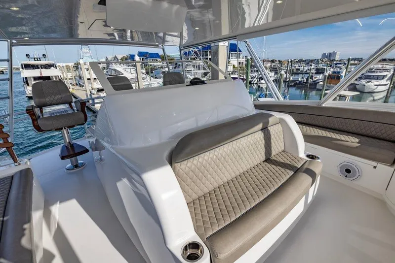 Slide: The Image of Luxurious interior of 2022 Viking 72 Convertible yacht at marina, featuring plush seating and helm. - 21