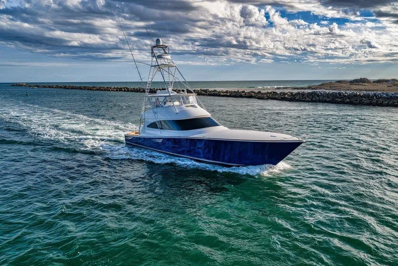 Slide: The Image of 2022 Viking 72 Convertible yacht cruising on open water under a cloudy sky. - 3