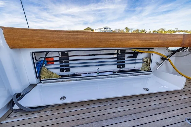 Slide: The Image of Storage compartment on 2022 Viking 72 Convertible yacht, featuring organized equipment and wooden accents. - 33