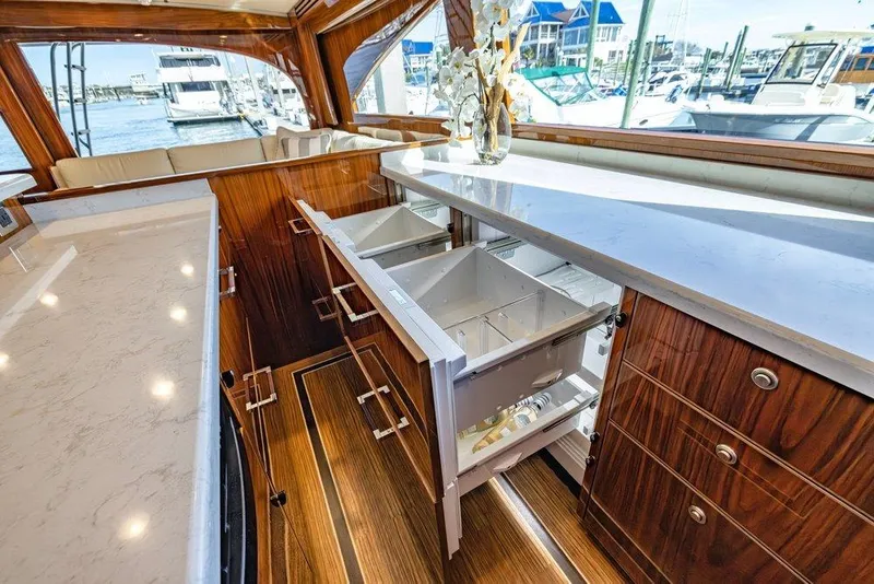 Slide: The Image of Luxurious interior of 2022 Viking 72 Convertible yacht with open drawers and elegant wood finish. - 45