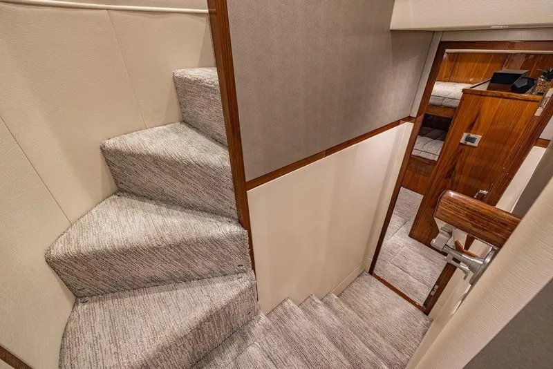 Slide: The Image of Interior staircase of 2022 Viking 72 Convertible yacht, featuring carpeted steps and wooden accents. - 50
