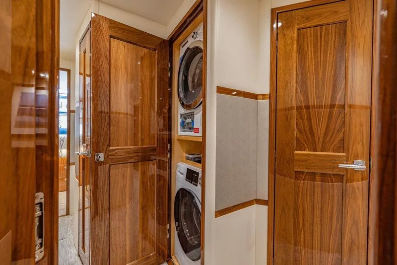 Slide: The Image of Luxurious 2022 Viking 72 Convertible yacht interior with wood paneling and laundry appliances. - 56