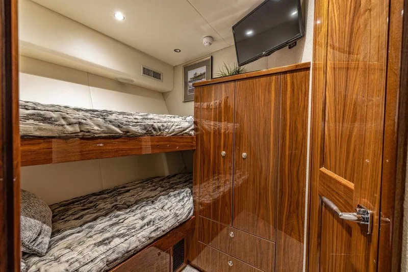 Slide: The Image of Luxurious cabin interior of 2022 Viking 72 Convertible yacht with wooden finishes and bunk beds. - 60