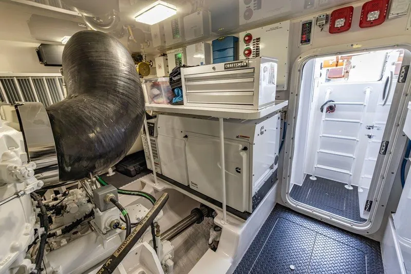 Slide: The Image of Engine room of 2022 Viking 72 Convertible yacht with tools and equipment. - 74