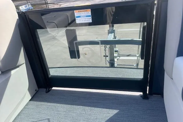 Slide: The Image of 2026 Godfrey Sweetwater 2286 SB boat interior with glass door and trailer view. - 20