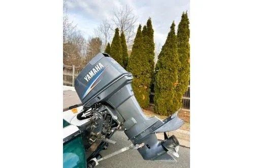 Slide: The Image of 2007 Skeeter SX170 boat with Yamaha outboard motor, parked near tall trees. - 4