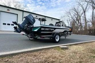 Slide: The Image of 2007 Skeeter SX170 boat parked outside a garage on a paved road. - 6