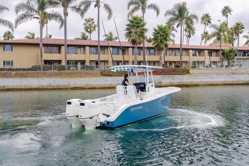Slide: The Image of 2020 Sea Prop center console boat cruising near waterfront buildings and palm trees. - 2