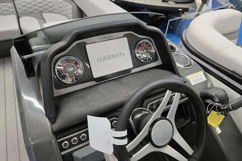 Slide: The Image of 2026 Godfrey Monaco 235 QSB dashboard with Garmin display and modern steering wheel. - 15