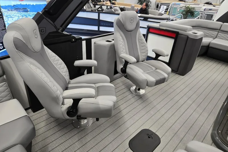 Slide: The Image of Luxurious seating on 2026 Godfrey Monaco 235 QSB pontoon boat, featuring plush gray captain chairs. - 29