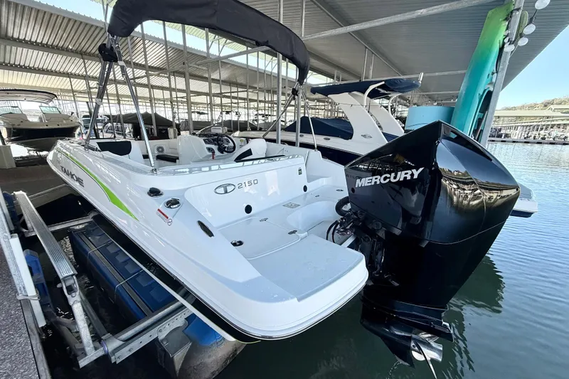 Slide: The Image of 2023 Tahoe 2150 boat with Mercury engine docked in a marina. - 18