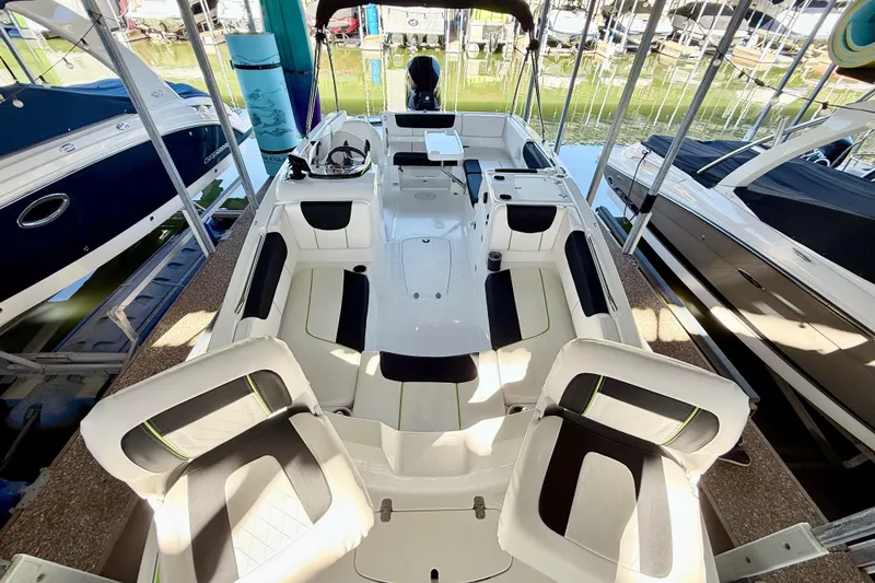 Slide: The Image of 2023 Tahoe 2150 boat interior with seating and helm, docked in marina. - 24
