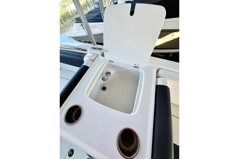 Slide: The Image of 2023 Tahoe 2150 boat interior with open storage compartment and cup holders. - 29