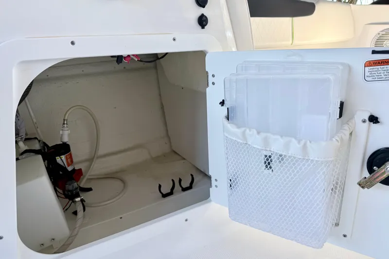 Slide: The Image of 2023 Tahoe 2150 boat storage compartment with netted pocket and equipment. - 30