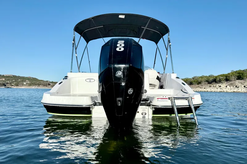 Slide: The Image of 2023 Tahoe 2150 boat with outboard motor on a calm lake. - 5
