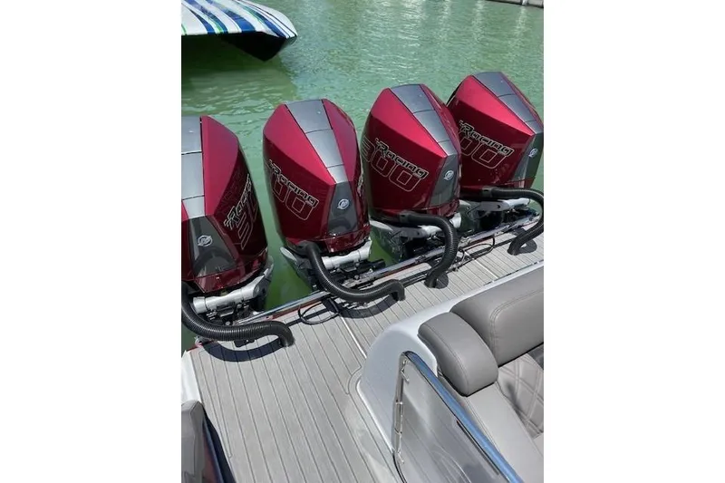 Slide: The Image of Four powerful outboard engines on a 2021 Mystic Powerboats M3800, docked on green water. - 15