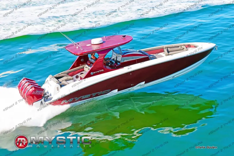 Slide: The Image of 2021 Mystic Powerboats M3800 cruising on vibrant blue water. - 2