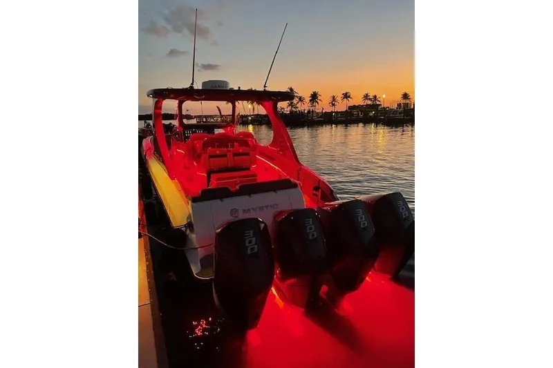 Slide: The Image of 2021 Mystic Powerboats M3800 illuminated at sunset with palm trees in the background. - 25