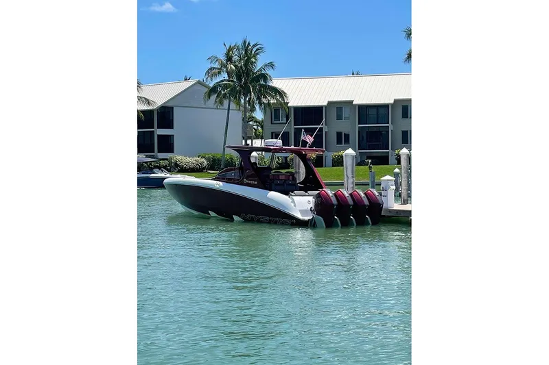 Slide: The Image of 2021 Mystic Powerboats M3800 docked in a sunny marina setting. - 3