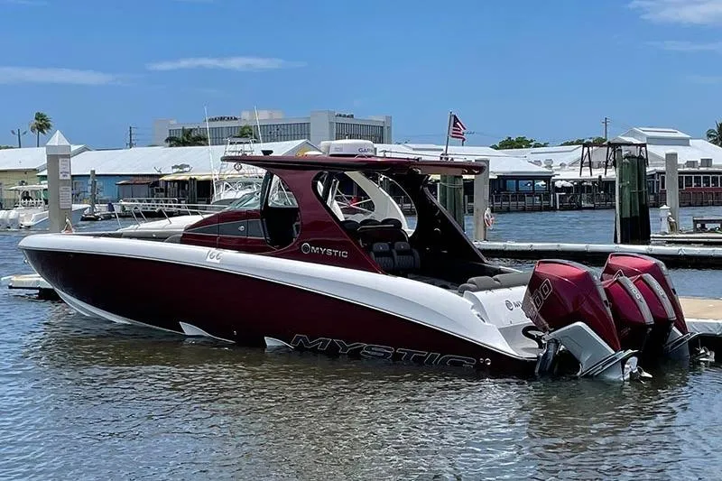 Slide: The Image of 2021 Mystic Powerboats M3800 in marina, featuring sleek design and dual outboard engines. - 5
