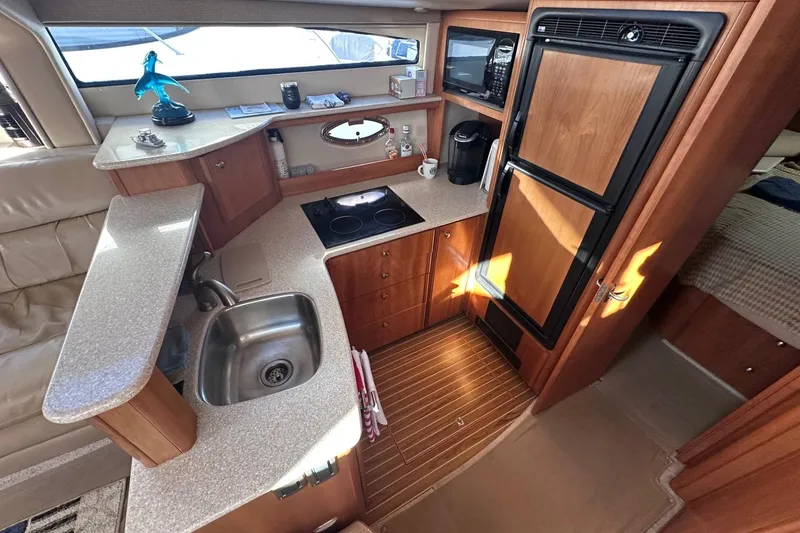Slide: The Image of 2004 Meridian 459 Motoryacht kitchen with sink, stove, and refrigerator. - 13