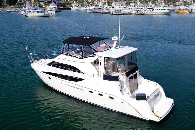 Slide: The Image of 2004 Meridian 459 Motoryacht on calm water, featuring sleek design and spacious deck. - 2