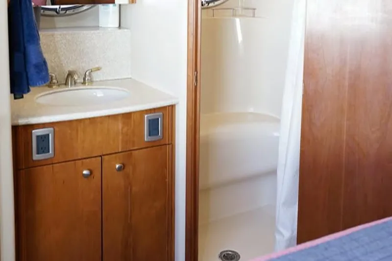 Slide: The Image of 2004 Meridian 459 Motoryacht bathroom with sink, wooden cabinets, and shower area. - 9