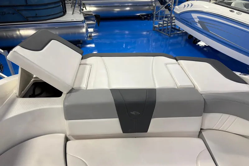 Slide: The Image of 2020 Chaparral 23 SSi boat interior with gray and white seating, open storage compartment. - 6