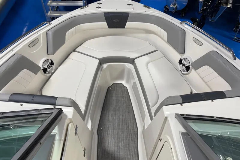 Slide: The Image of 2020 Chaparral 23 SSi boat interior with gray and white seating, speakers, and carpeted flooring. - 8
