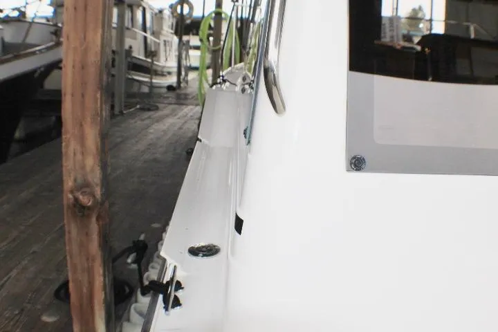 Slide: The Image of 2020 Ranger Tugs R-27 docked, showcasing sleek white exterior and marina setting. - 21