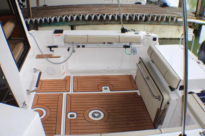Slide: The Image of 2020 Ranger Tugs R-27 boat interior with teak flooring and cushioned seating. - 23