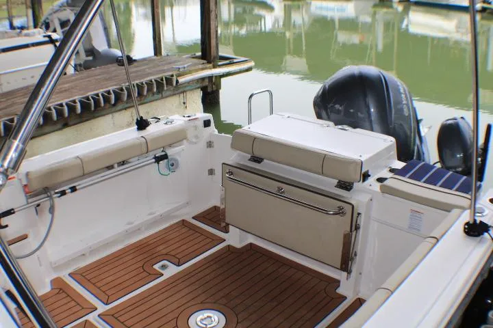 Slide: The Image of 2020 Ranger Tugs R-27 boat interior with teak flooring and cushioned seating. - 24