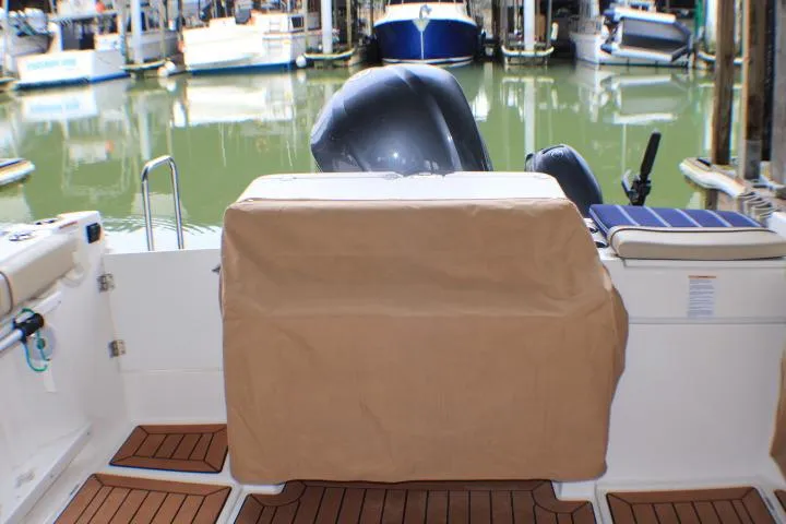 Slide: The Image of 2020 Ranger Tugs R-27 boat stern view with covered engine at marina. - 30