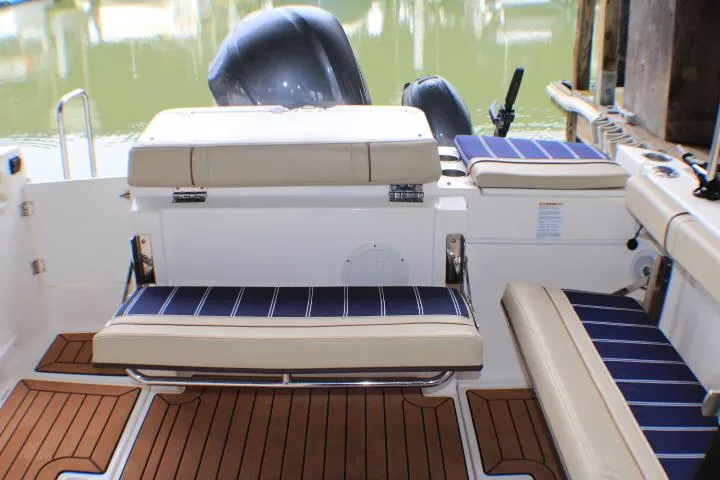 Slide: The Image of 2020 Ranger Tugs R-27 boat interior with cushioned seating and wood flooring. - 31