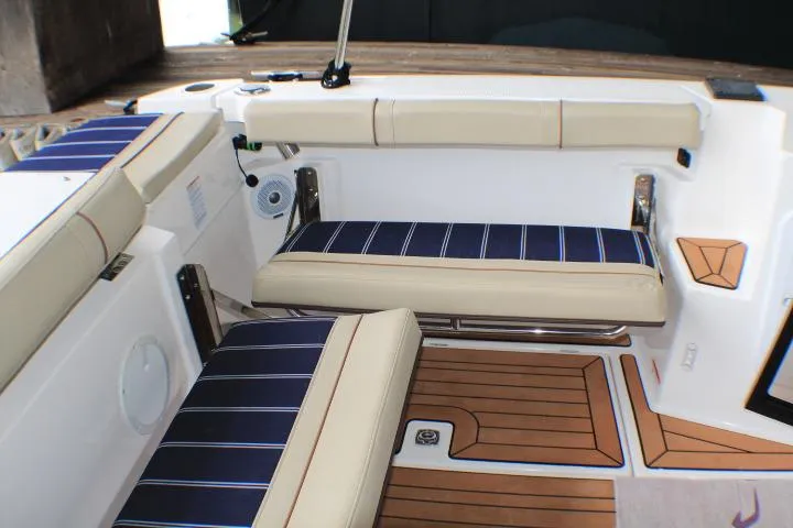 Slide: The Image of 2020 Ranger Tugs R-27 interior with cushioned seating and wood-style flooring. - 32