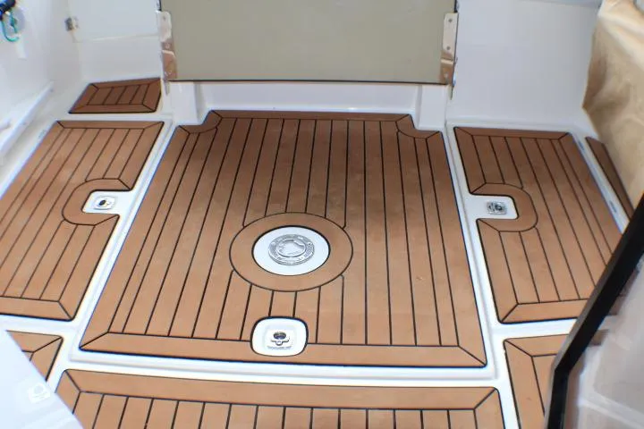 Slide: The Image of 2020 Ranger Tugs R-27 boat deck with teak-style flooring and drainage features. - 33