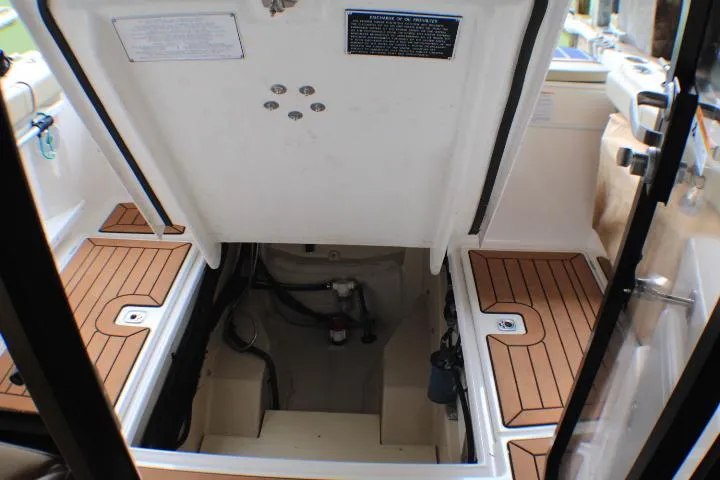 Slide: The Image of 2020 Ranger Tugs R-27 engine compartment with teak flooring and open hatch. - 35