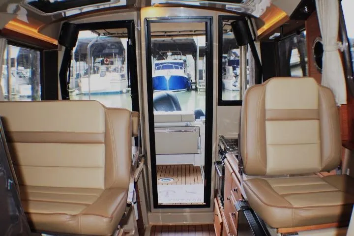 Slide: The Image of Interior of 2020 Ranger Tugs R-27 boat with tan seating and marina view. - 41