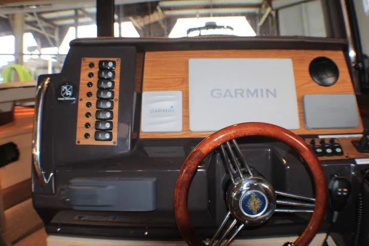 Slide: The Image of 2020 Ranger Tugs R-27 dashboard with Garmin navigation and wooden steering wheel. - 48