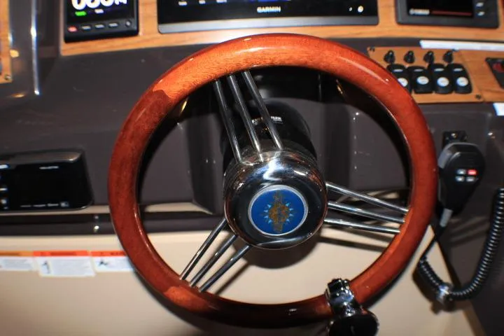 Slide: The Image of Steering wheel of 2020 Ranger Tugs R-27 boat, featuring wood finish and control panel. - 49