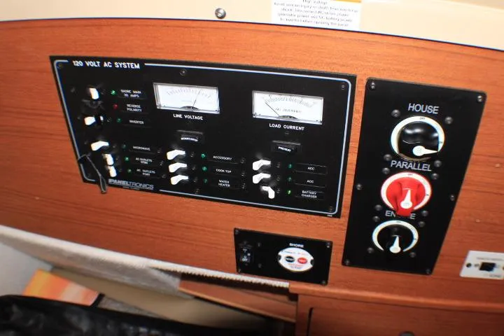 Slide: The Image of Control panel of a 2020 Ranger Tugs R-27 boat, featuring 120-volt AC system gauges. - 54