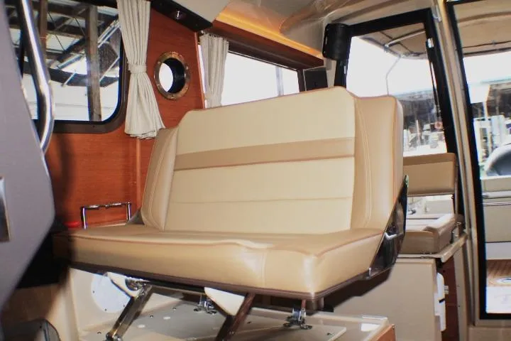 Slide: The Image of Interior of 2020 Ranger Tugs R-27 boat with beige seating and wooden accents. - 55