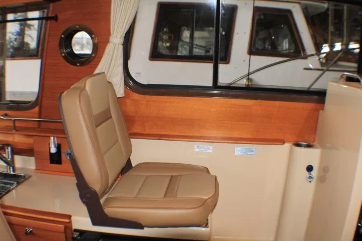 Slide: The Image of 2020 Ranger Tugs R-27 interior with tan seating and wooden accents. - 56