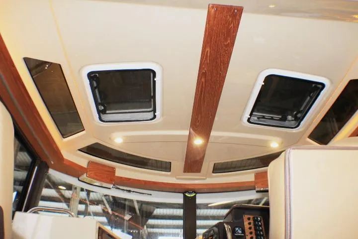 Slide: The Image of Interior ceiling of 2020 Ranger Tugs R-27 boat with wood accents and skylights. - 58