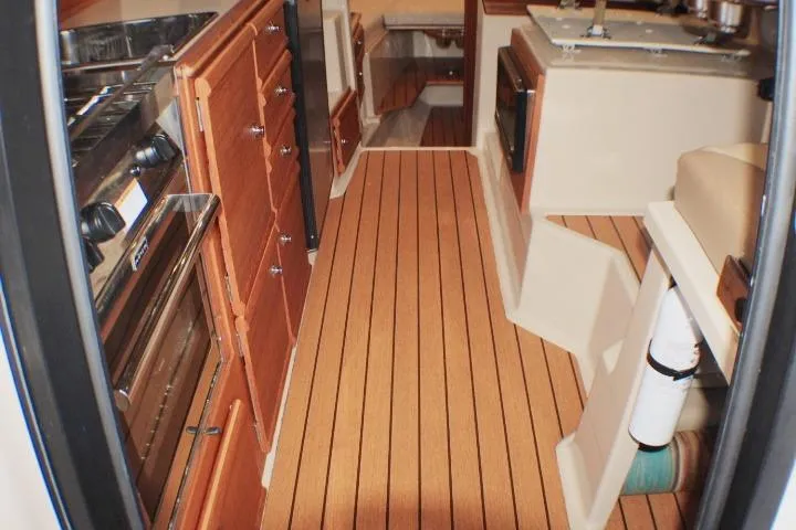 Slide: The Image of Interior of 2020 Ranger Tugs R-27 boat with wood flooring and kitchen amenities. - 59